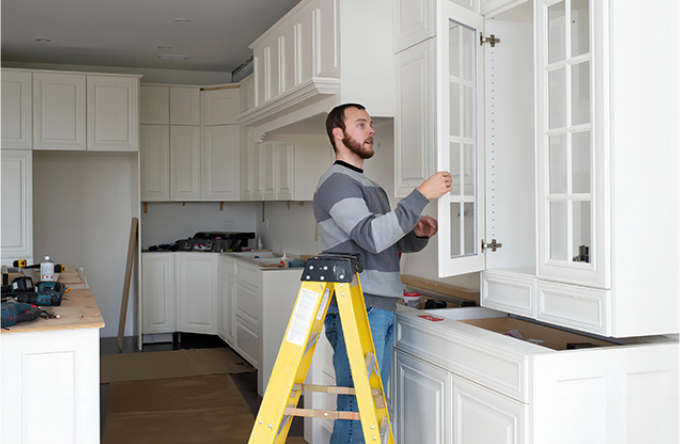 worker installing kitchen cabinets on-site during a renovation project-ais